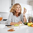 Woman smiling while eating healthy snack at home