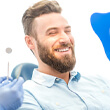 bearded man beaming at his reflection after getting dental implants in Waverly