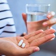 Lady prepares to take pills with water