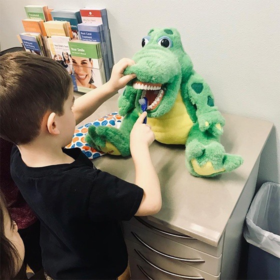 child brushing dinos teeth