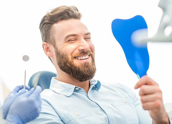 man smiling into mirror