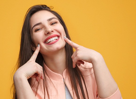 Smiling woman pointing to her teeth