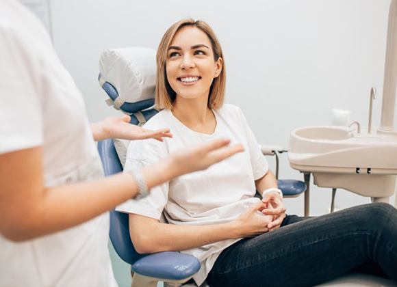 smiling woman talking with her dentist