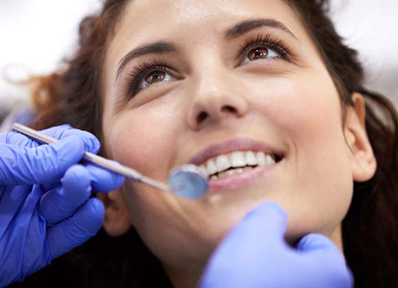 Woman preventing dental emergencies in Waverly by completing a checkup