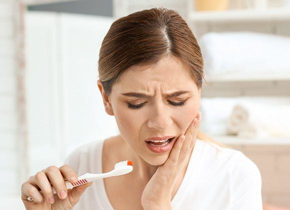 woman holding brush in pain