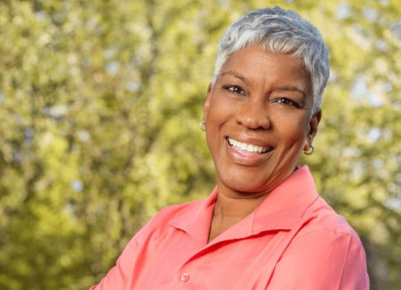 woman in coral shirt smiling
