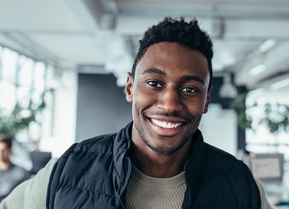 man smiling in vest