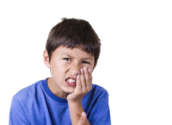 little boy holding mouth in pain against white background 