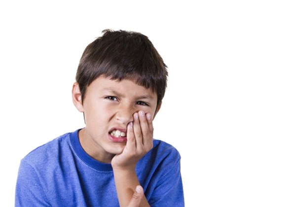 little boy holding mouth in pain against white background