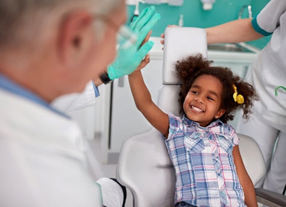 little girl giving her dentist a high-five 