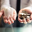 Tooth being balanced with a pile of coins