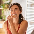 a woman smiling while brushing her teeth 