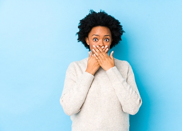 Woman hiding teeth, in need of smile makeover in Waverly