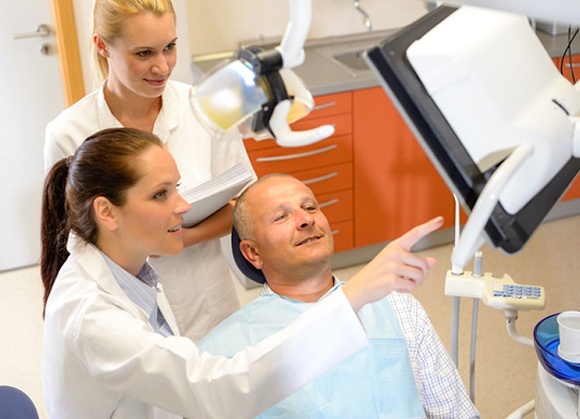 Patient discussing smile makeover with dental office team members