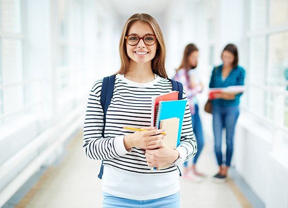 girl at school holding books