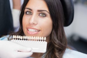 woman smiling with a shade guide