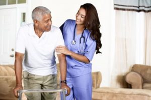 A man using a walker getting help from a nurse to walk