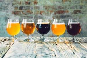 five beers sitting on a wood table