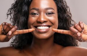 Woman smiling and pointing to her teeth